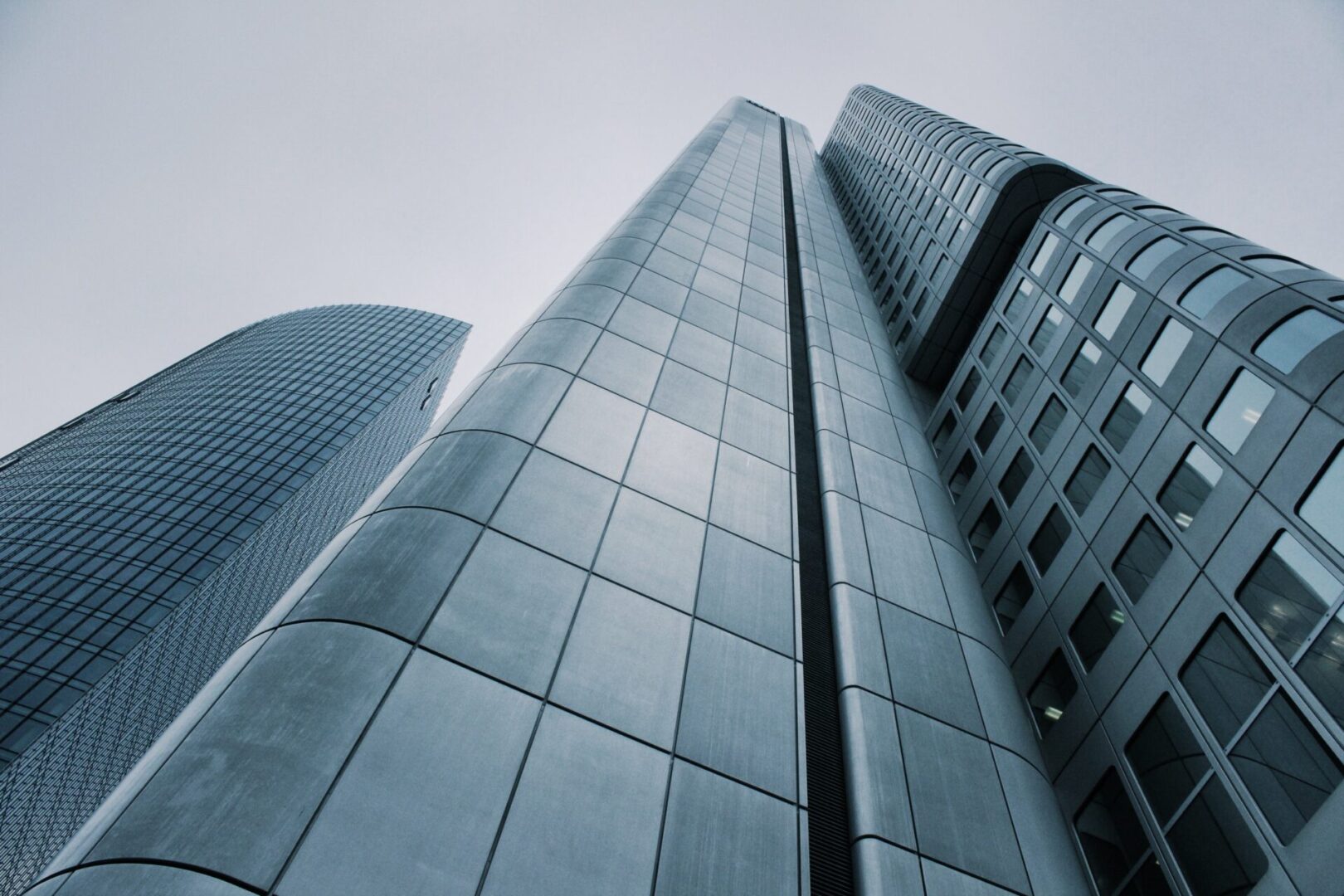 A view of some tall buildings from the ground up.